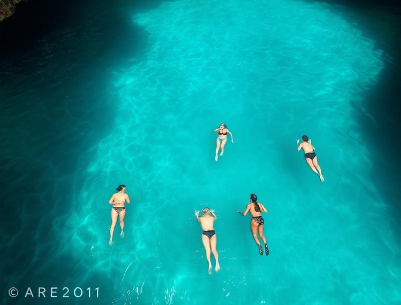 Swimmers in turquoise crystal water at cenote